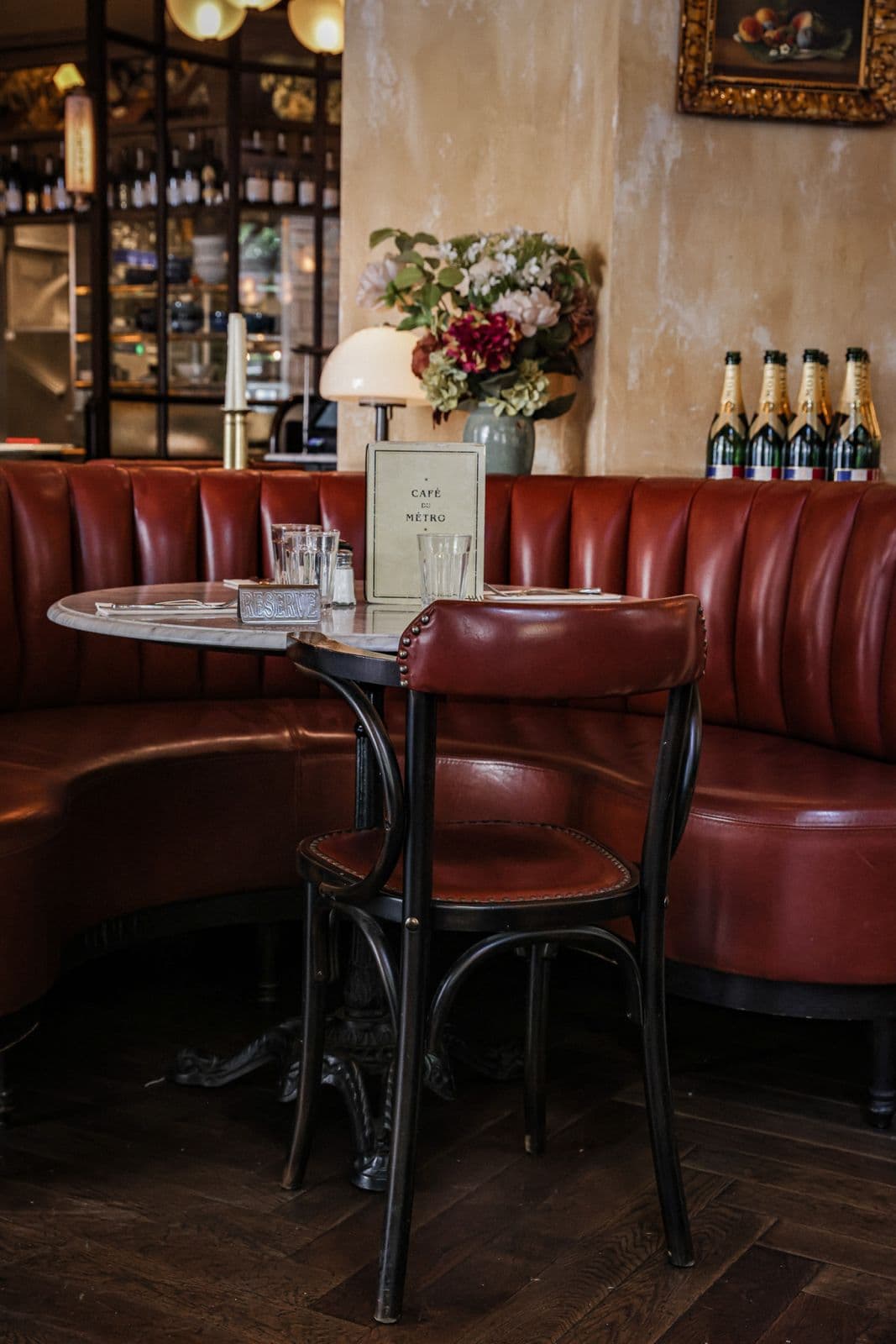 Salle vide aux parquets en chevrons et chaises bistrot